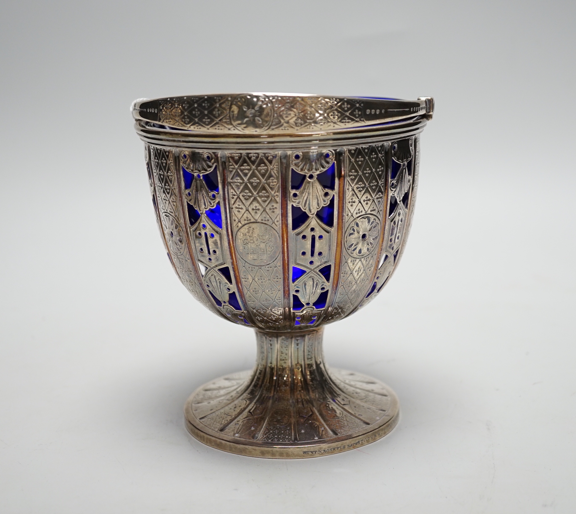 A Victorian pierced silver pedestal sugar basket, by John Samuel Hunt, London, 1859, with blue glass liner, height 13.1cm excluding handle, 12.4oz.